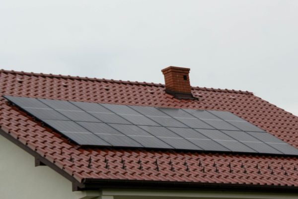 Installing a Solar Cell on a Roof. High quality photo Installing a Solar Cell on a Roof. Solar panels on roof. Historic farm house with modern solar panels on roof and wall. High quality photo